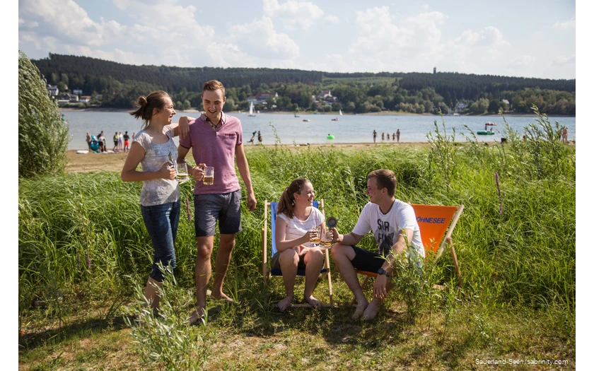 Freunde trinken zusammen ein Bier auf der Liegewiese