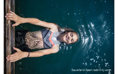 Kleines Mädchen macht Kunststücke am Steg