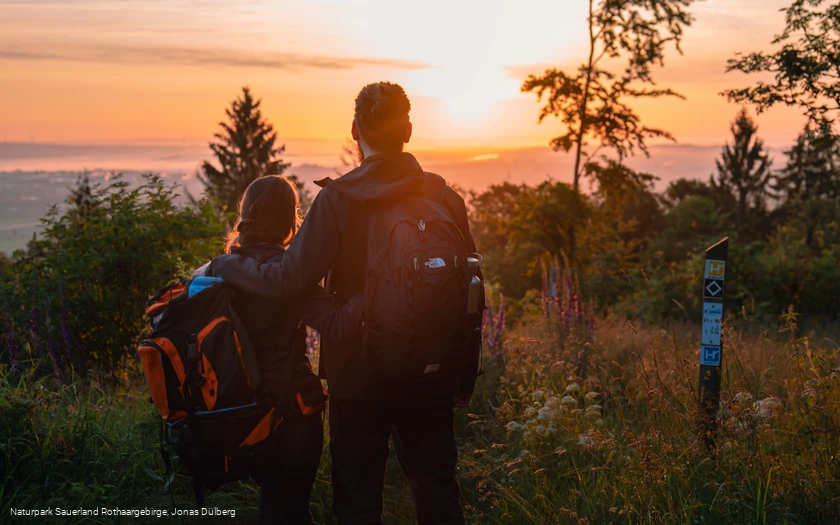 Wanderpaar vor Sonnenaufgang am Eisenberg in Korbach