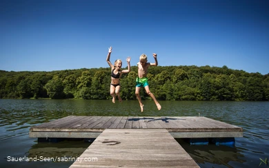 Kinder springen auf einem Steg herum