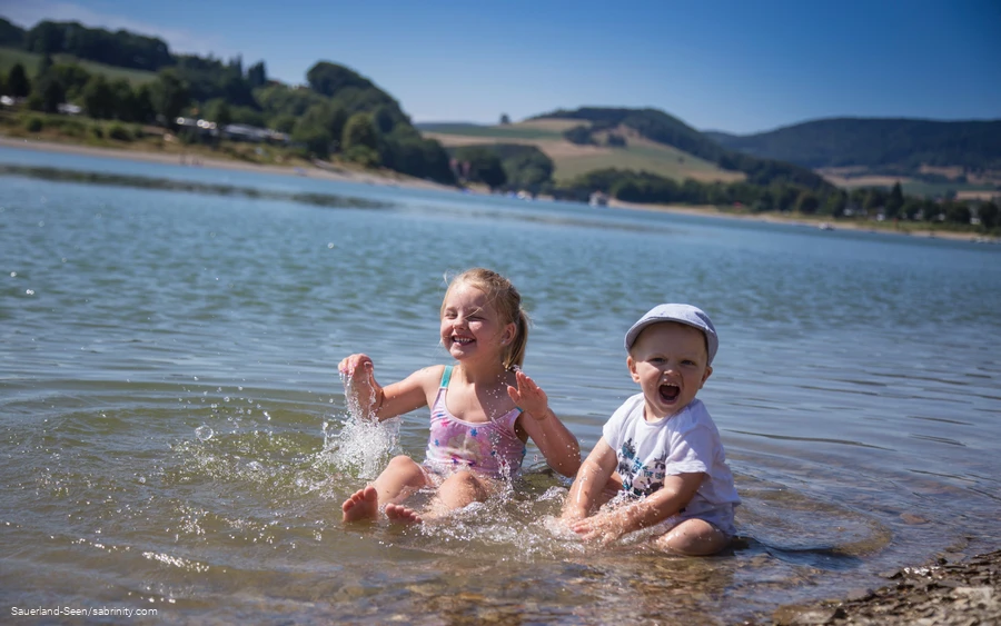 Zwei Kleinkinder planschen im kühlen Nass