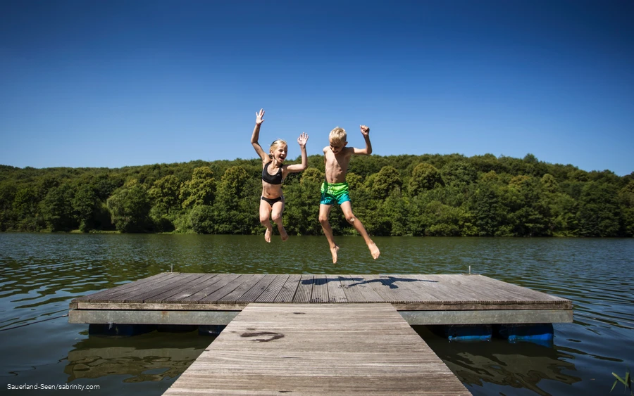 Kinder springen auf einem Steg herum