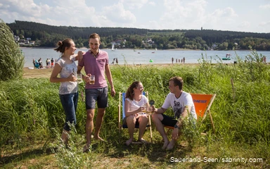 Freunde trinken zusammen ein Bier auf der Liegewiese