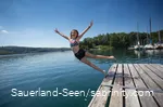 Mädchen lässt sich am Sorpesee vom Steg ins Wasser fallen
