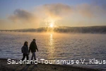 Wanderer am Möhnesee bei Sonnenaufgang