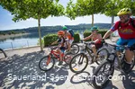 Familie fährt auf Mountainbikes über die Promenade am See