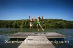 Kinder springen auf einem Steg herum